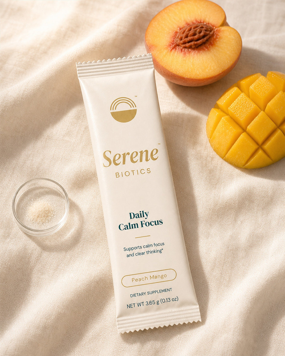 The cream serving beside a fresh peach and cut mango on linen