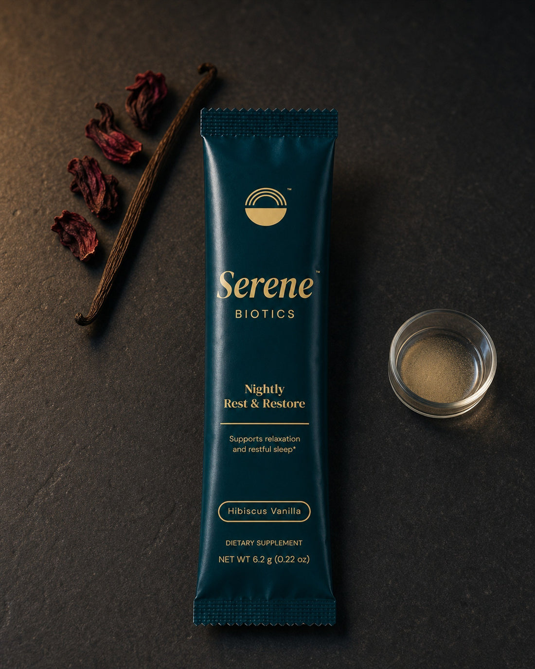 The teal serving beside dried hibiscus petals and a split vanilla pod on dark stone
