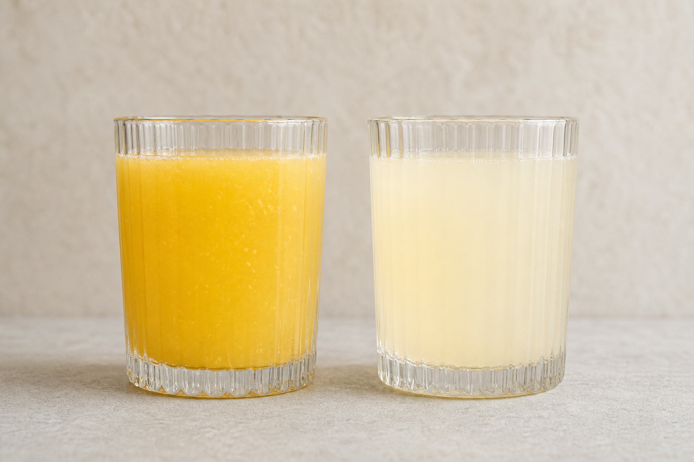 Daily Calm Focus prepared in one glass, a bright cloudy Peach Mango pour, beside Nightly Rest & Restore, a pale Hibiscus Vanilla pour
