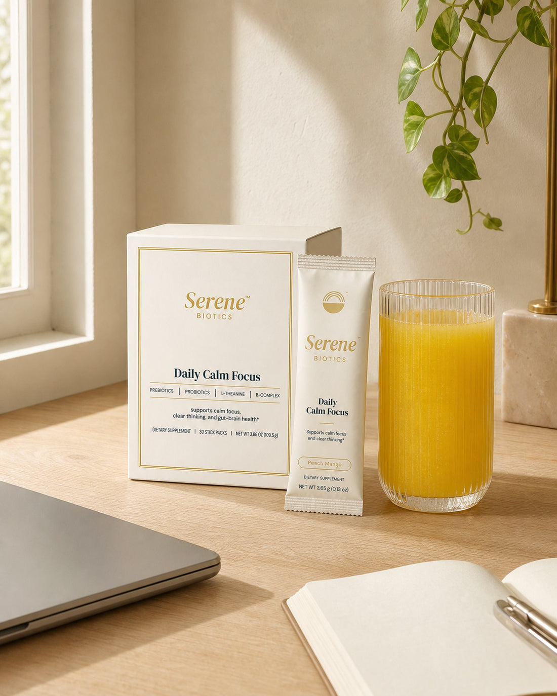Daily Calm Focus on a sunlit morning desk with the golden drink, notebook, and laptop